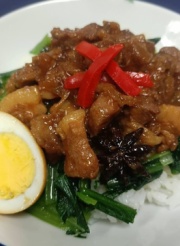 施設の食事。豚肉と野菜の炒め物に卵がトッピングされた温かい料理
