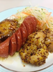 食堂で提供される食事。ソーセージ、炒飯、野菜炒めなどが盛られた一皿