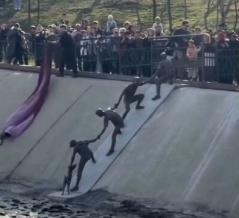 「手をつないで人間ロープと化し、犬を救った瞬間の像」が10年越しに建てられる