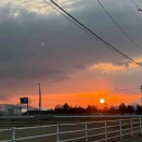 雪解けの田んぼに染まる夕空