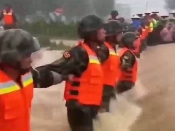 中国兵士、洪水が発生したためスクラム組んで人間土嚢を形成し水を防ごうとする！